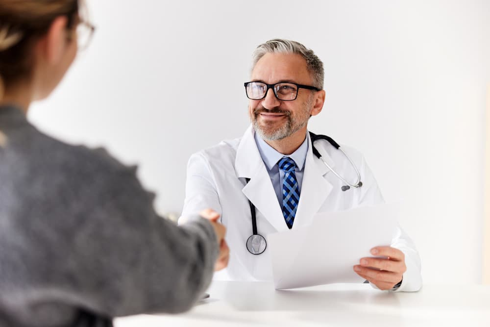 Male doctor shaking hands with patient