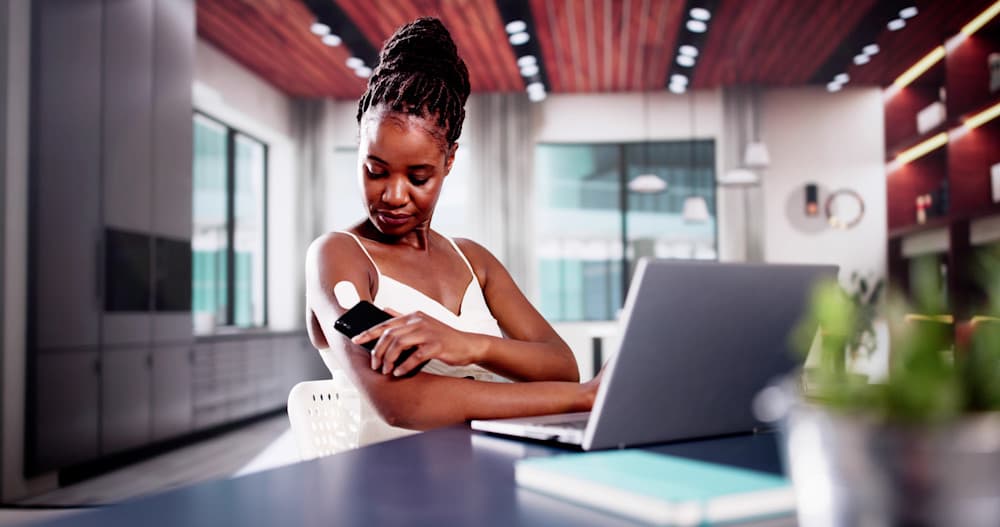 Woman Testing Glucose Level With Continuous Glucose Monitor