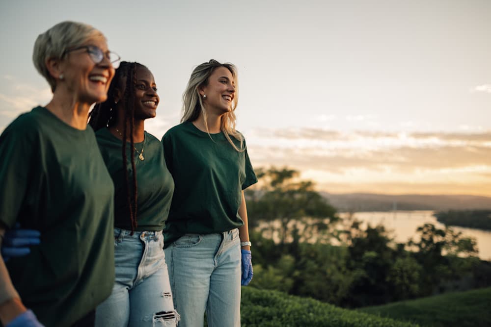 Women walking and admiring the sunset over the river