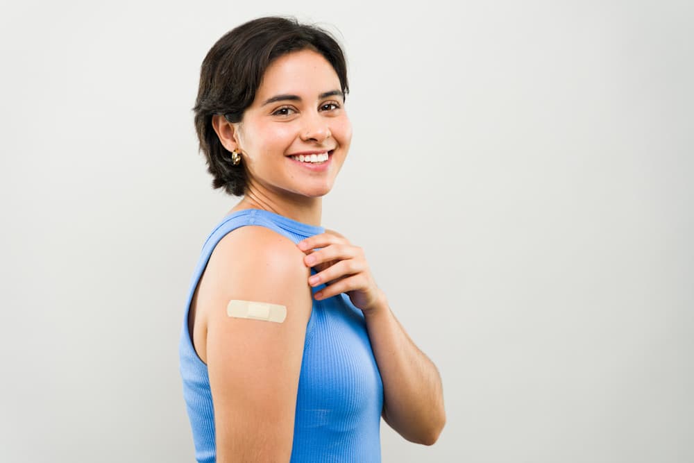 Happy, confident young woman smiles brightly after getting a vaccine