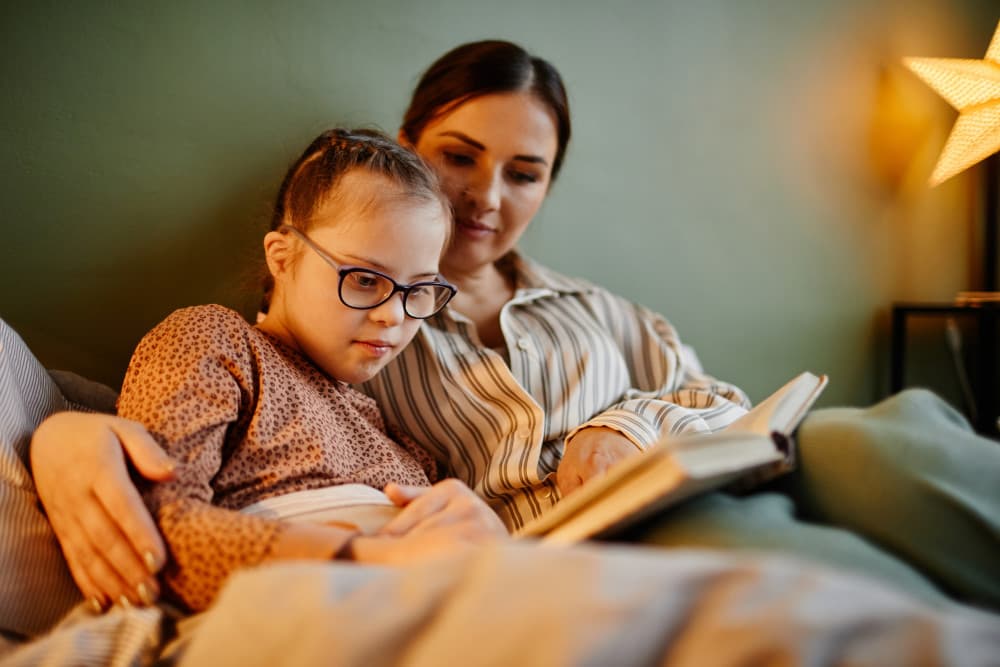 Mother and Daughter Reading Book at Night