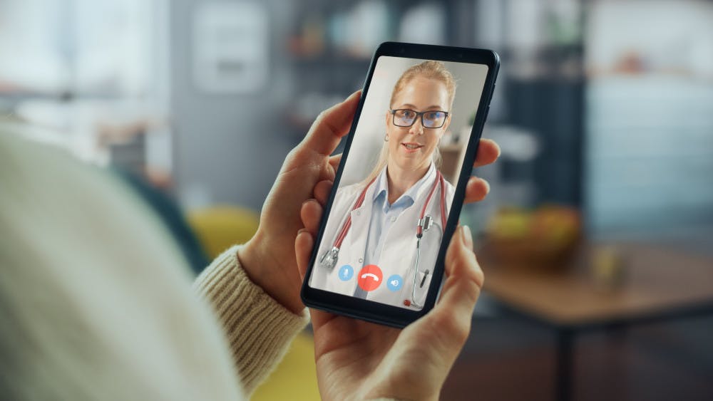 Close Up of a Female Chatting in a Video Call with Her Family Doctor on Smartphone from Living Room.