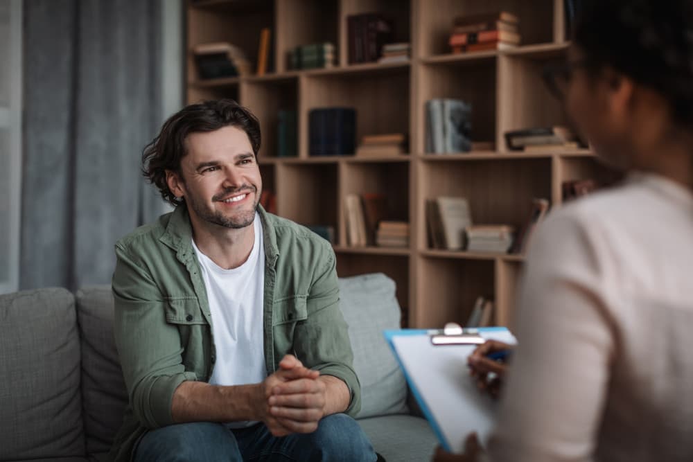 woman psychologist consults smiling european guy in modern clinic