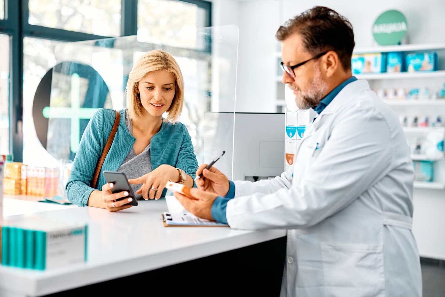 Mid adult woman buying prescription medicine in drugstore