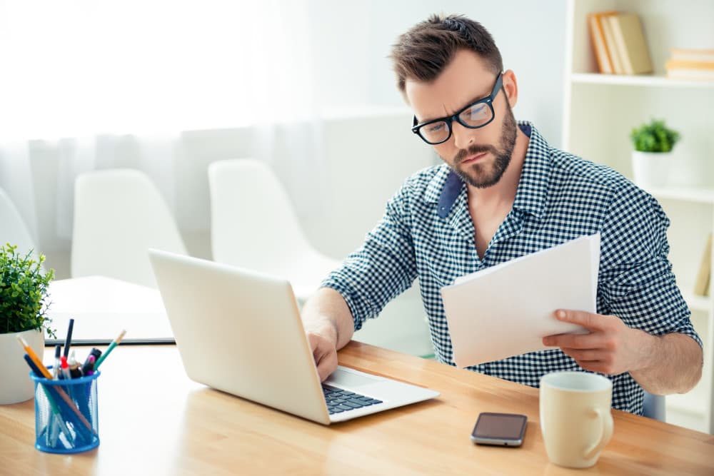 Confused man looking at bills