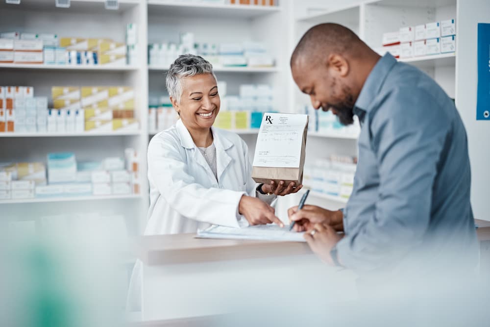 patient picking up prescription from local pharmacy