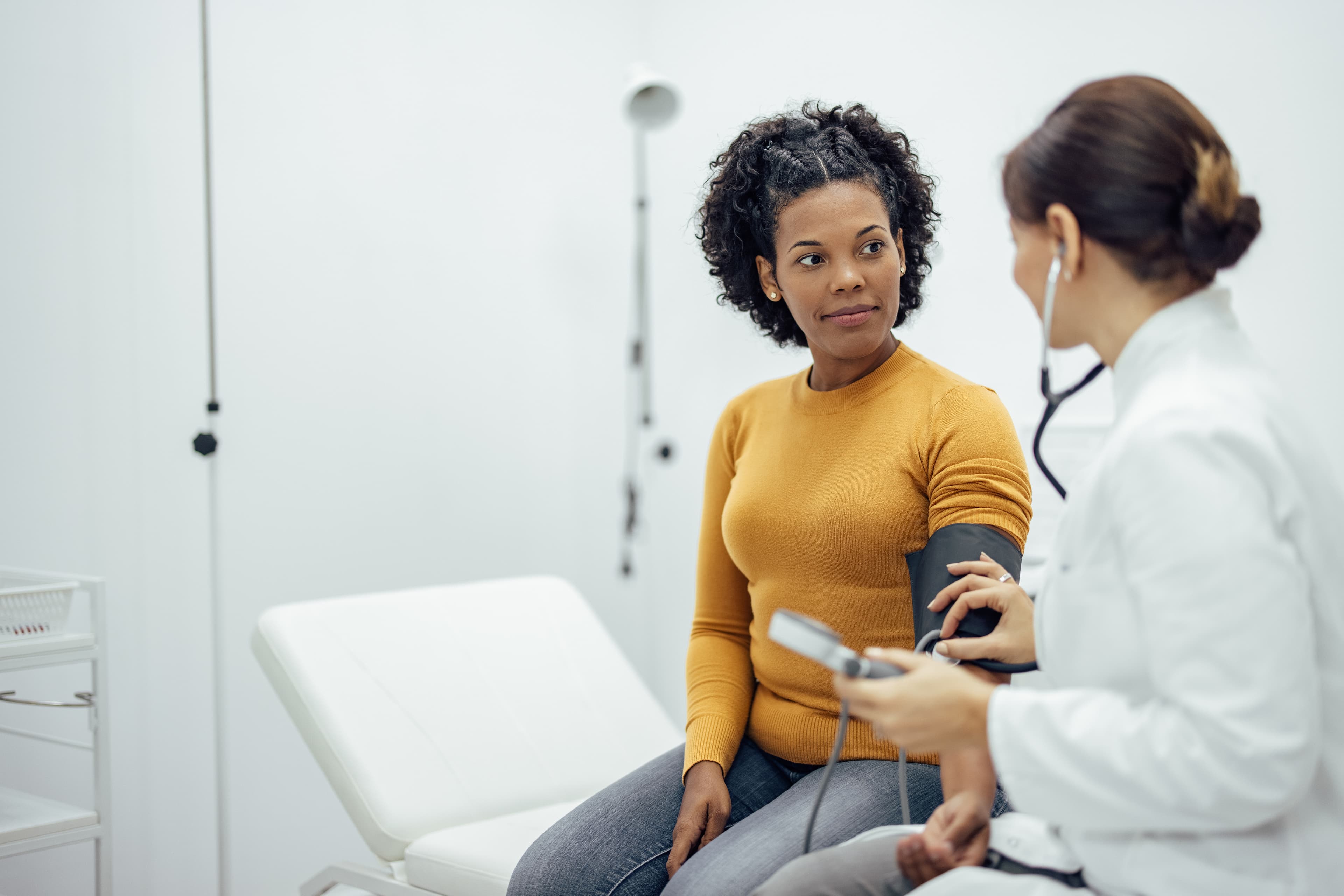 Female patient having her blood pressure taken by female doctor as part of the Curative health plan