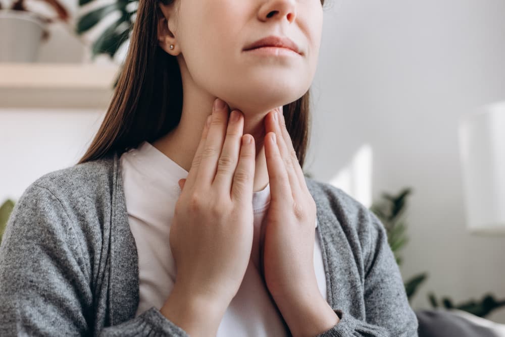 Woman feeling her thyroid