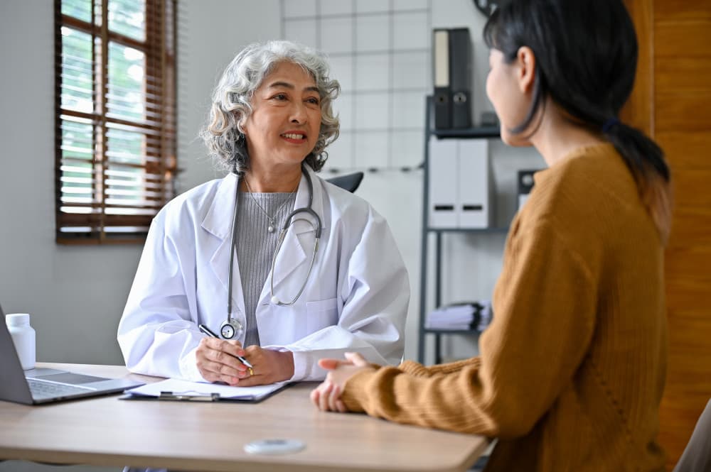 Professional female doctor is talking to a young patient in the clinic about colonoscopies.